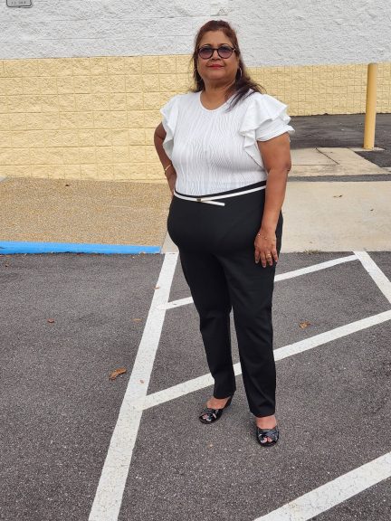 Plus size woman wearing a black & white outfit standing confidently on zebra crossing lines.